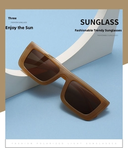 Detail of square amber sunglasses with thick acetate frames on geometric props