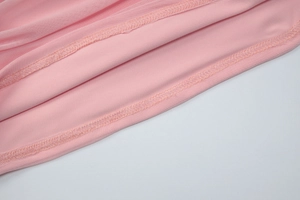 Detail of pink mesh and knit fabric stitching with high-quality hemmed finish