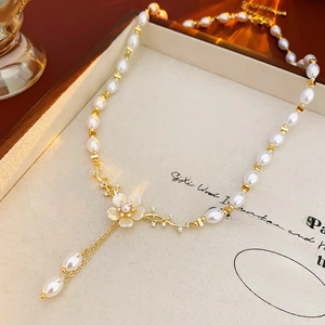 Détail d'un collier de perles en Y avec fleur en zircon et élégants glands raffinés