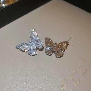 Macro view of butterfly stud earrings with sparkling cubic zirconia on silver plating