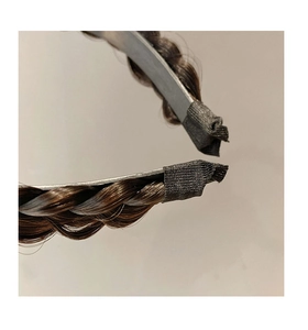 Detailed close-up of dark brown braided hair headband with fabric protective ends
