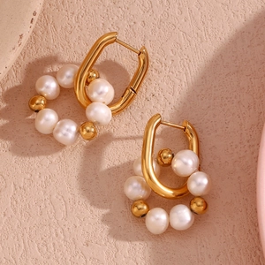 Vue détaillée des boucles d'oreilles en U dorées avec perles d'eau douce et billes