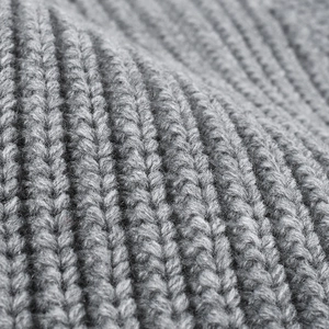 Close-up of thick grey ribbed knit beanie showing soft wool texture and warm fabric detail