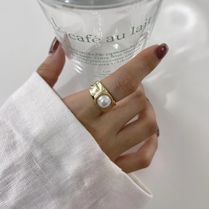 Detail of s925 gold-plated pearl ring with unique textured band on hand