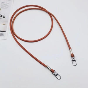 Brown PU leather crossbody strap with silver metal swivel hooks on white background