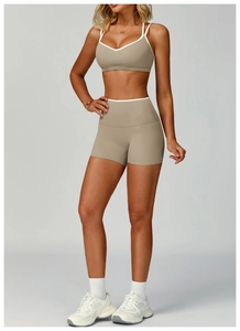Dettaglio del set yoga kaki con bordi bianchi a contrasto e reggiseno sportivo a V