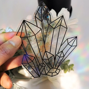 Detail showing rainbow suncatcher stickers with holographic crystal patterns on glass