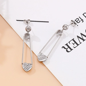 Détail de boucles d'oreilles épingle à nourrice argentées avec zircon cœur et strass