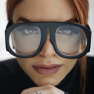 Close-up of oversized black fashion glasses with thick frames and light gray lenses