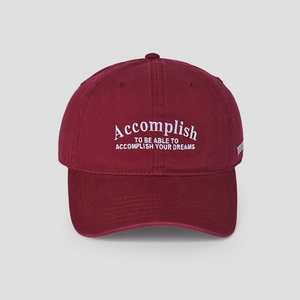 Detailed close-up of white embroidery on a wine red cotton baseball cap crown
