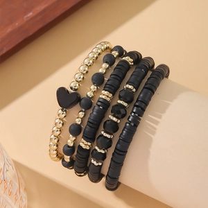 Bohemian multilayer bracelet set featuring black heishi beads and golden heart pendant