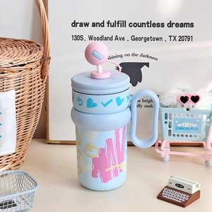 Detail of light blue stainless steel tumbler with pink straw cover and heart pattern