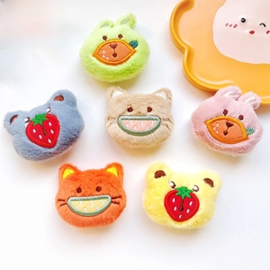 Close-up of colorful plush bear and cat brooches with fruit embroidery details