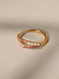 Dettaglio anello placcato oro 18k con pavé di zirconi rosa e accenti di perle bianche fini