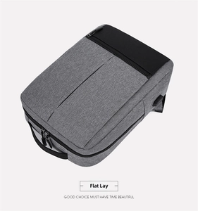 Close-up of business backpack showing USB charging port and textured grey oxford fabric
