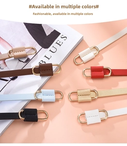 Collection of slim colorful fashion belts with oval gold metal buckles on a coral surface
