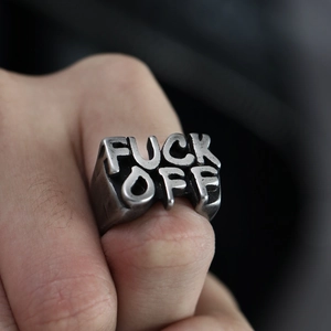 Macro shot of punk style stainless steel ring with relief FUCK OFF lettering in vintage silver
