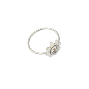 Detailed close-up of a silver stainless steel ring with white flower design element