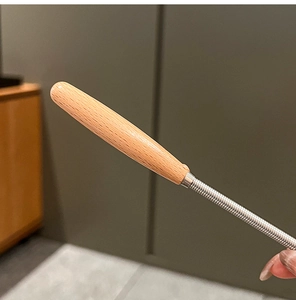 Close-up of a stainless steel whisk with an ergonomic wooden handle for home baking