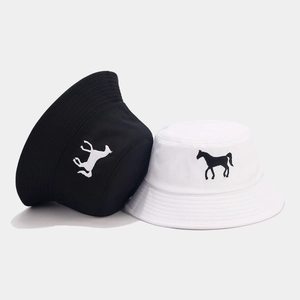 Détail de la broderie cheval sur des bobs en toile de coton noir et blanc de qualité