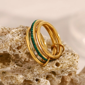 Detail of multi-layer 18K gold plated stainless steel ring with emerald green zircon stones