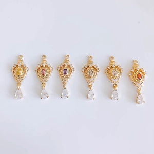 Macro view of six gold-plated crown pendants with multi-colored gems and teardrop stones