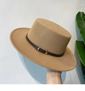 Detail of camel wool felt fedora featuring a stylish brown leather buckle strap