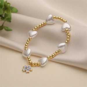 Chic beaded bracelet with gold beads, imitation pearls, and a purple flower pendant