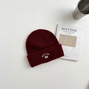Detail of dark red wool knit beanie featuring white BOSTON 23 embroidery in retro style