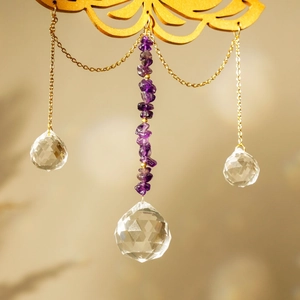 Close-up of golden lotus suncatcher with amethyst stones and hanging crystal prisms