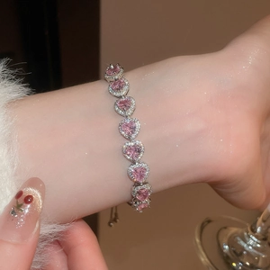 Close-up of heart-shaped pink zircon bracelet with diamond halo on a model's wrist