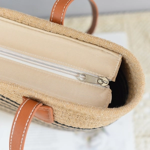 Detailed top view of a woven tote bag featuring a secure zipper closure and durable PU handles
