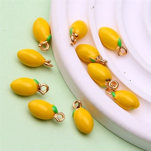 Detail of yellow enamel mango charms with golden loops for DIY jewelry making