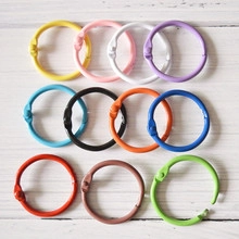 Colorful heart-shaped alloy keychains arranged in multiple colors on a white wood surface