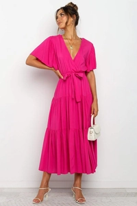 Detalle del cuello en V y lazo en la cintura de un vestido largo bohemio fucsia de manga corta