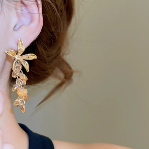 Gros plan de boucles d'oreilles fleurs avec cristaux champagne portées par un mannequin