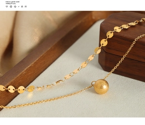 Detail of 18k gold double-layer necklace with flat sequins and a frosted sphere pendant