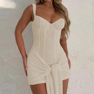 Dettaglio dell'abito in pizzo beige con scollo a V e nastro in vita per un tocco elegante