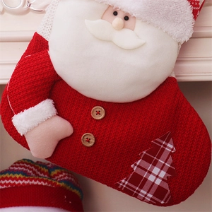 Detailed knit texture of a red Christmas stocking with plush Santa and wood buttons