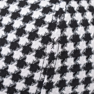 Close-up of black and white houndstooth fabric with detailed stitching on baseball cap