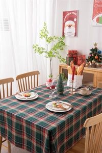 Close-up of red and green plaid Christmas tablecloth with decorative tassel edge details