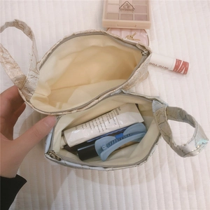 Detail of jacquard floral canvas mini pouch showing interior lining and makeup storage