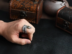 Macro detail of vintage snake ring with realistic scale texture on an antique wooden box