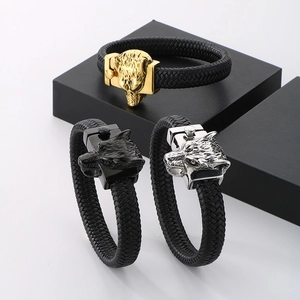 Close-up of wolf head bracelets in gold, silver, and black finish on geometric stands