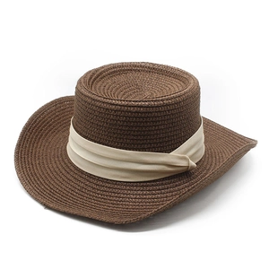 Detail of the woven texture and beige pleated ribbon on this flat top straw sun hat