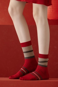 Gros plan de chaussettes de Noël rouges en laine avec rayures kaki et marron sur mannequin
