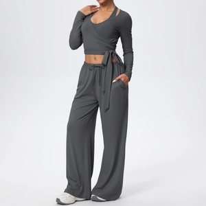 Vue détaillée de l'ensemble de yoga gris foncé avec haut à manches longues croisé et pantalon large