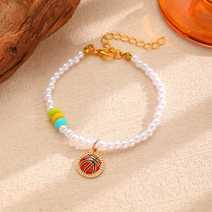 Détail d'un bracelet en perles avec perles colorées et breloque pendentif basket rouge