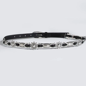 Detail of vintage bohemian belt with silver sunburst studs and oval buckle detail