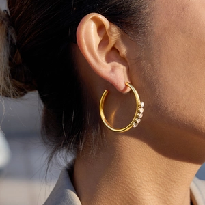 Polished 18K gold stainless steel hoop earring with five sparkling zircon stones on model